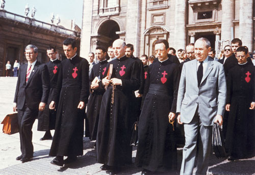 L'abbé de Nantes, entouré de ses frères et de membres de la CRC, se dirige vers le palais du Saint-Office, le 13 mai 1983, pour y remettre le deuxième Liber. L'abbé de Nantes, entouré de ses frères et de membres de la CRC, se dirige vers le palais du Saint-Office, le 13 mai 1983, pour y remettre le deuxième Liber.
