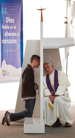 In Brazil, Pope Francis is hearing the confession of a young penitent who has kept his Rosary in his hand.