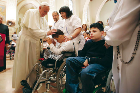 Pope Francis blesses young disabled children in Assisi.