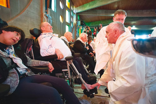 Pope Francis washes and embraces the feet of poor disabled people on Maundy Thursday.
